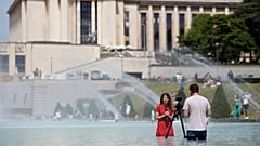 خبرنگار فرانسوی در فواره میدان تروکادرو در پاریس، ۲۵ ژوئن ۲۰۱۹.