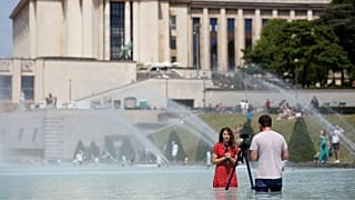 خبرنگار فرانسوی در فواره میدان تروکادرو در پاریس، ۲۵ ژوئن ۲۰۱۹.