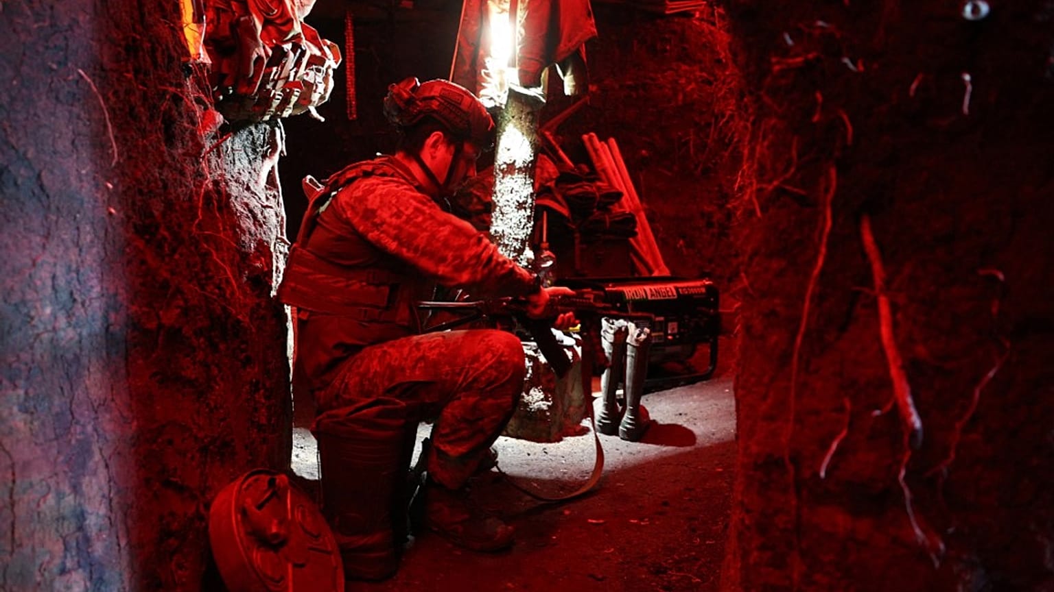 A Ukrainian serviceman from the K-2 battalion checks his weapon in a dugout in the Donetsk region, on July 12, 2023, amid the Russian invasion of Ukraine.