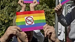 Grupos contrarios a la comunidad LGTB sostienen una bandera arcoíris con pegatinas anti LGTB durante el primer desfile del Orgullo Gay del país, el 10 de octubre de 2017, en Pristina, capital de Kosovo.