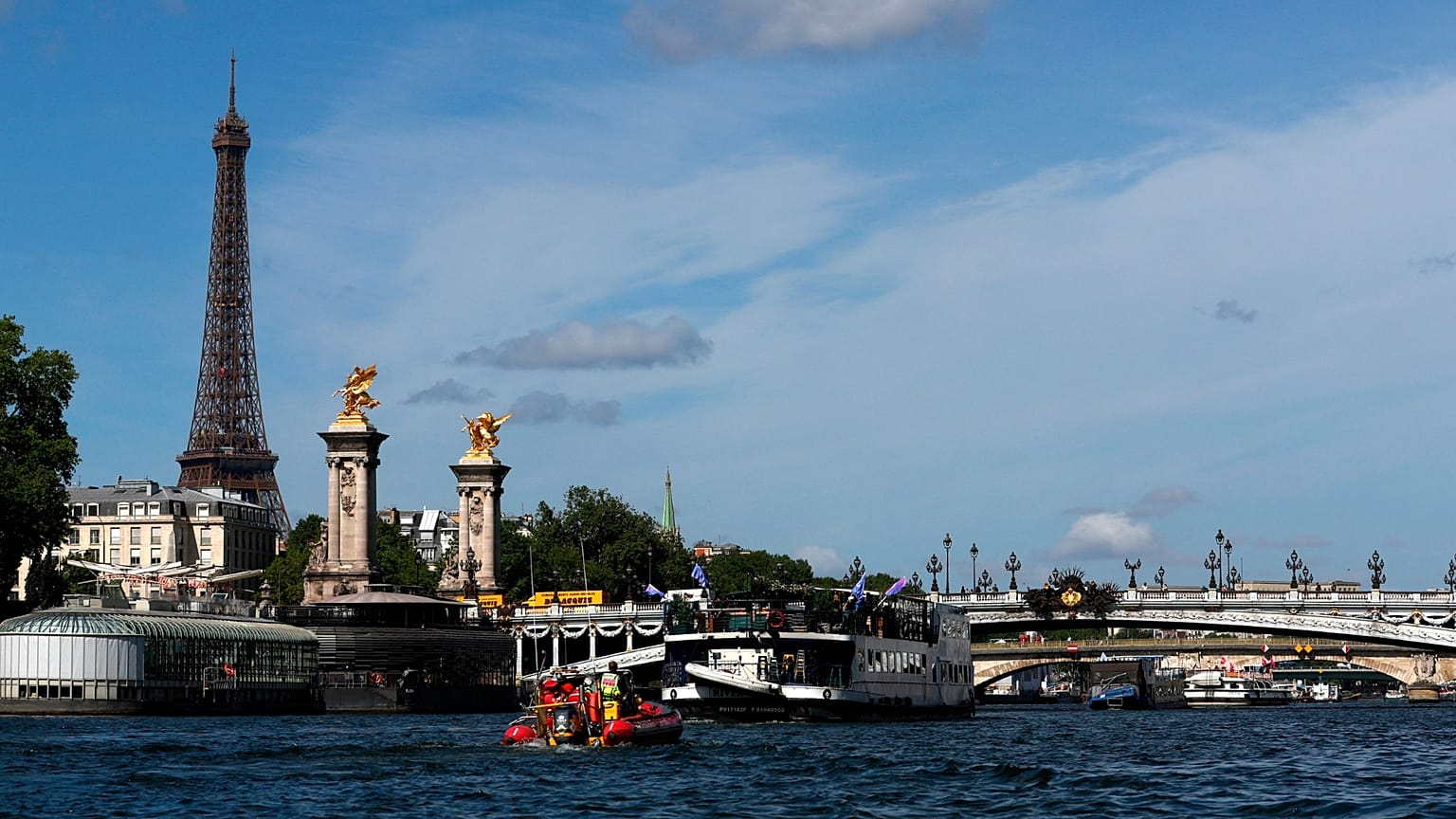 A Torre Eiffel espreita o Sena enquanto se realiza um teste com barcos nos preparativos para o desfile da cerimónia de abertura.dos JO