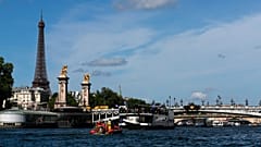 A Torre Eiffel espreita o Sena enquanto se realiza um teste com barcos nos preparativos para o desfile da cerimónia de abertura.dos JO