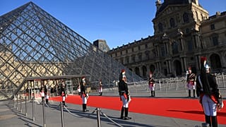 Republican Guards stand alongside the Louvre museum pyramid in Paris before a dinner to honour Indian Prime Minister Narendra Modi July 14