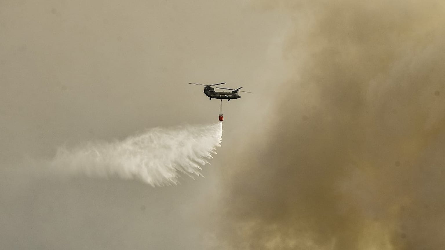 A military Chinook helicopter flies over the area of Magoula, 25 km southwest of Athens on July 18, 2023