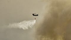 A military Chinook helicopter flies over the area of Magoula, 25 km southwest of Athens on July 18, 2023