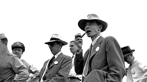 Dr. J. Robert Oppenheimer, University of California physicist, smokes his pipe as he contemplates the site on Sept. 9, 1945.