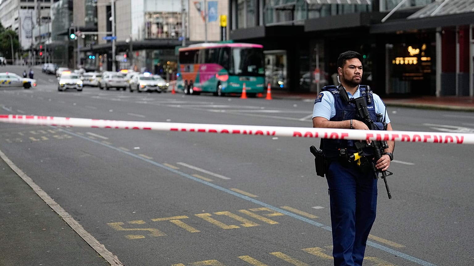 Silahlı bir Yeni Zelanda polisi, 20 Temmuz 2023 Perşembe günü Yeni Zelanda'nın Auckland kentinde meydana gelen bir silahlı saldırının ardından merkezi iş bölgesindeki bir yol barikatında duruyor.