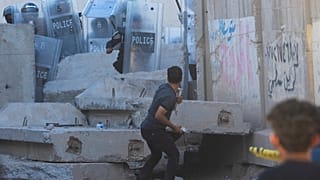 Un Irakien jette une pierre lors d'affrontements avec les forces de sécurité devant l'ambassade de Suède à Bagdad, en Irak (20 juillet 2023)