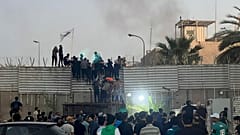 متظاهرون يتسلقون جداراً في السفارة السويدية في بغداد، 20 يوليو 2023. 