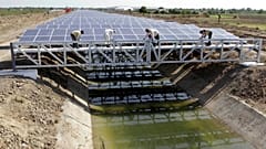 Indische Arbeiter legen letzte Hand an die Solarpaneele, die den Narmada-Kanal im Dorf Chandrasan außerhalb von Ahmadabad, Indien, abdecken, April 2012\. 