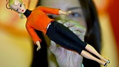 A young woman holds a "Bild Lilli" doll from 1955 at the "World of Barbie" exhibition in Rostock, Germany. 12 April 2006