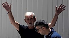 ضابط شرطة يرافق البريطاني ديفيد هنتر بعد محاكمته بتهمة القتل غير العمد لزوجته، قبرص، الجمعة 21 يوليو 2023.