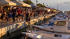 Holidaymakers walk by the harbor, in the Adriatic town of Rovinj, Croatia