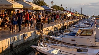Holidaymakers walk by the harbor, in the Adriatic town of Rovinj, Croatia