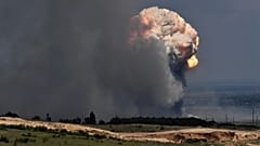 Un panache de fumée s'élève au-dessus d'un dépôt de munitions où des explosions se sont produites dans le district de Kirovsky en Crimée, mercredi 19 juillet 2023.