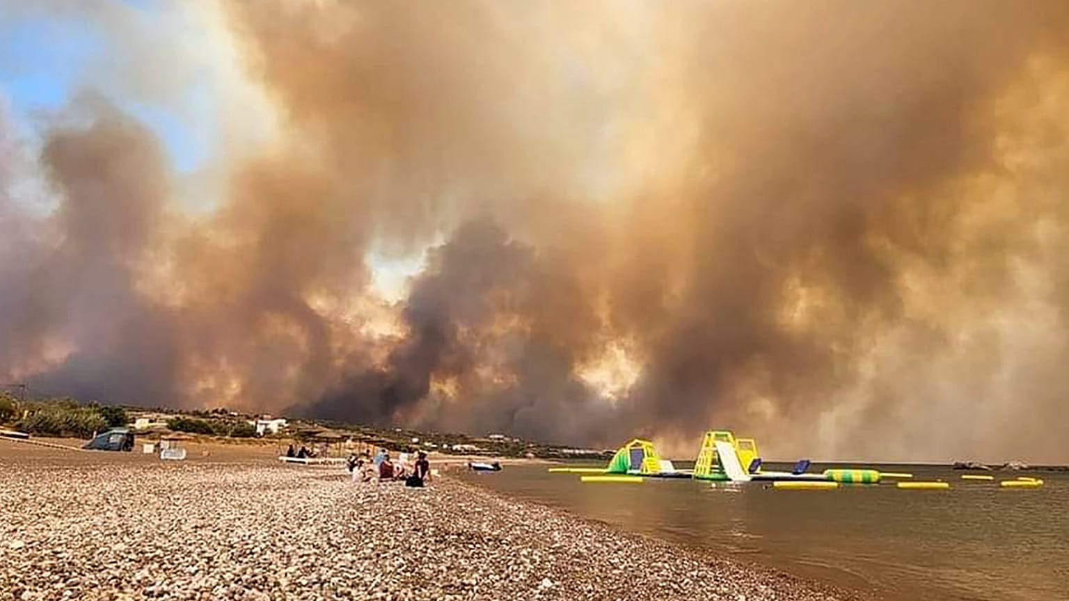 Des nuages de fumée provenant d'un feu de forêt s'élèvent dans le ciel de l'île de Rhodes, en Grèce, le samedi 22 juillet 2023.
