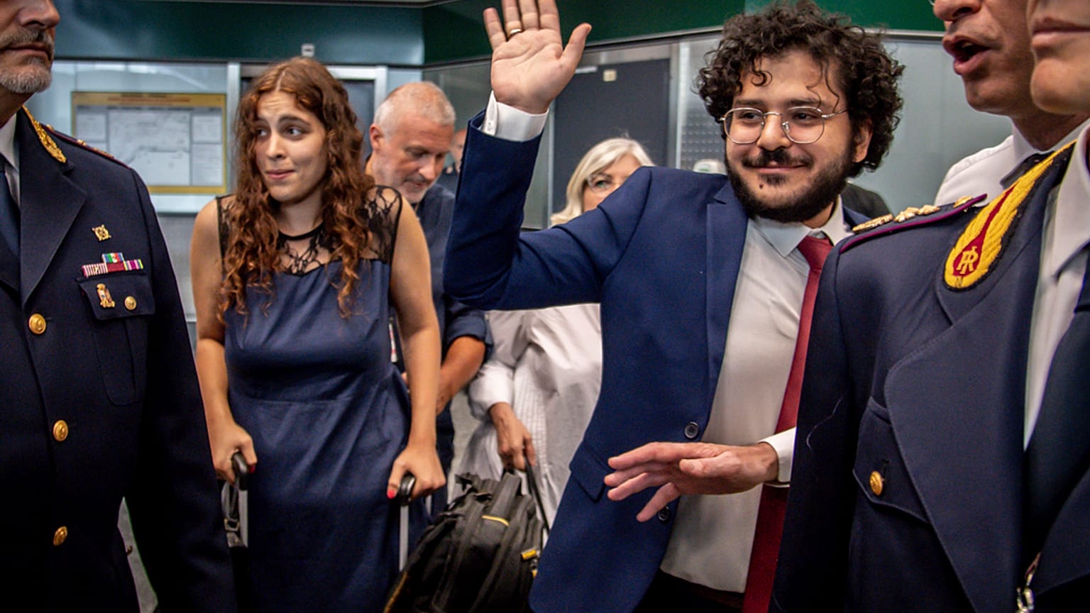 Patrick Zaki waves upon his arrival at the Milan Malpensa airport, Italy, Sunday, July 23, 2023. 