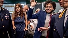 Patrick Zaki waves upon his arrival at the Milan Malpensa airport, Italy, Sunday, July 23, 2023. 