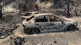 بقایای سوخته خودروها در جادهای پس از آتش سوزی جنگلها در یونان