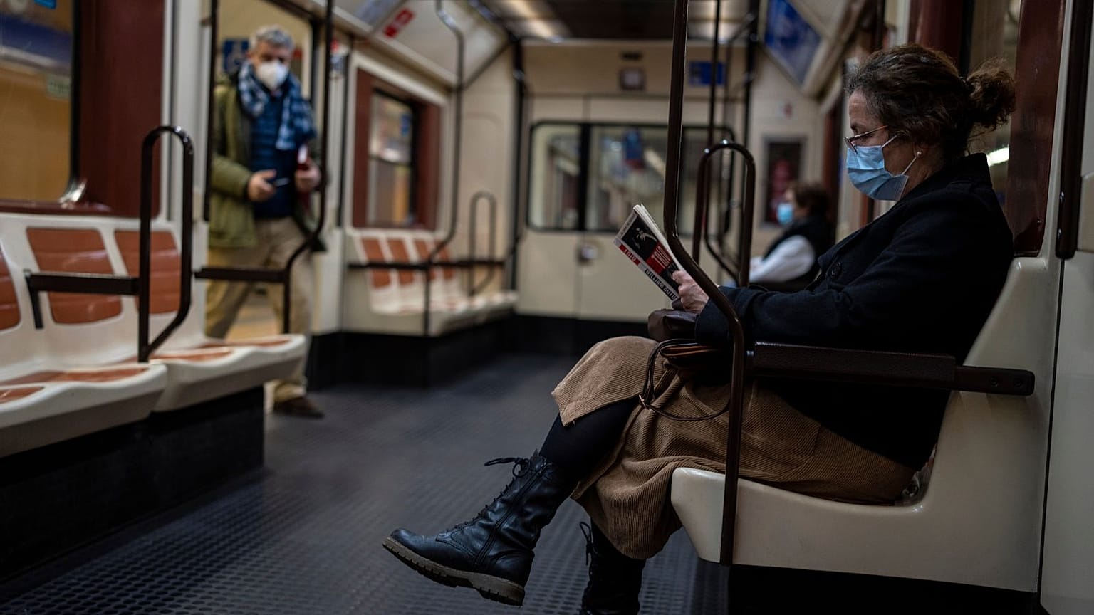 Une femme portant un masque facial lit un livre dans le métro de Madrid, Espagne, jeudi 20 janvier 2022.