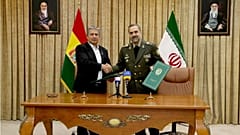 محمدرضا آشتیانی، وزیر دفاع ایران در سمت راست و ادموندو نوبیو آگیلار وزیران دفاع بولیوی در سمت چپ
