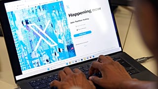 A person poses for a photo signing into the Twitter website which is now displaying the new logo