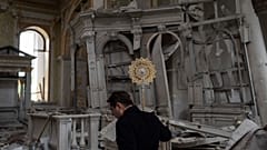 A church personnel salvages items while helping clean up inside the Odesa Transfiguration Cathedral after it was heavily damaged in Russian missile attacks in Odesa, Ukraine