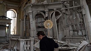 A church personnel salvages items while helping clean up inside the Odesa Transfiguration Cathedral after it was heavily damaged in Russian missile attacks in Odesa, Ukraine