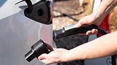 Electric vehicle driver attaches the EVject safety adapter to a Tesla charging head. 