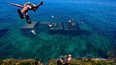 Um homem mergulha para as águas do Mediterrâneo em Beirute, Líbano