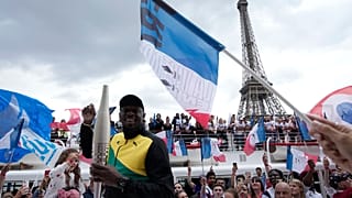 Usain Bolt, antigo atleta jamaicano, segura a tocha olímpica na terça-feira, 25 de julho de 2023, em Paris, França