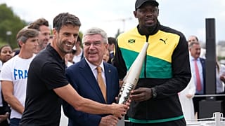 IOC-Präsident Thomas Bach an der Seite von Usain Bolt in Paris am 25. Juli 2023