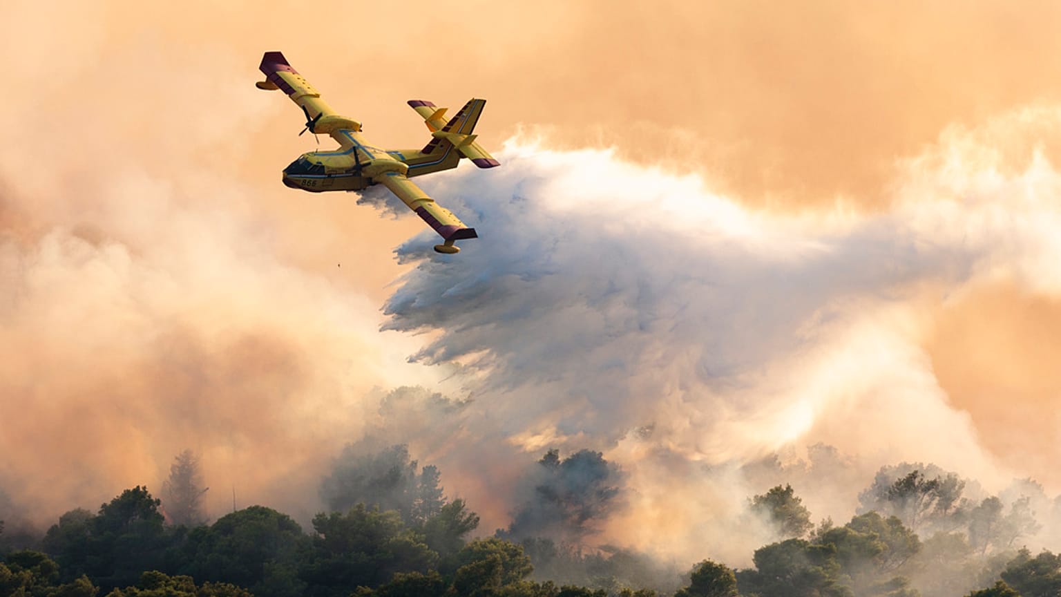 Un avión de bomberos rocía agua para extinguir un incendio forestal en la isla de Ciovo, Croacia, jueves 27 de julio de 2023.