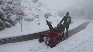 Un hombre despeja la nieve caída este miércoles 26 de julio, en la cima del Nebelhorn, en los Alpes bávaros