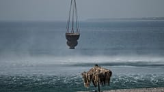 A helicopter fills water from the sea during a wildfire, near Gennadi village, on the Aegean Sea island of Rhodes, southeastern Greece, on Thursday, July 27, 2023.