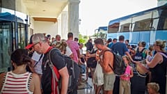 Evacuees wait to board on buses as they leave their hotel during a forest fire on the island of Rhodes, Greece