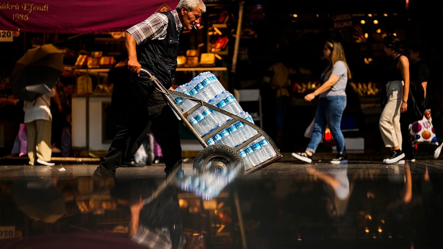 A man pushes a trolley with bottles of water on a hot summer day, in Istanbul, Turkey, July 13, 2023.