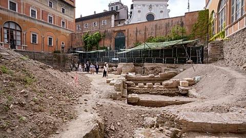 People walk in the excavation site of the ancient Roman emperor Nero's theater, 1st century AD, backdropped by the church of Santo Spirito in Sassia, in Rome.