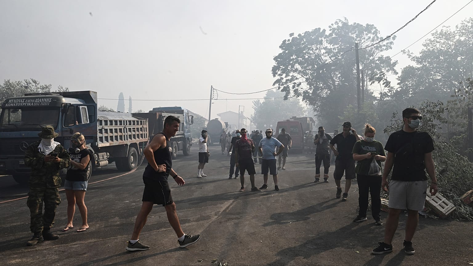 Residentes locales permanecen en la carretera durante un incendio forestal en la localidad de Nea Anchialos, cerca de la ciudad de Volos, Grecia central.