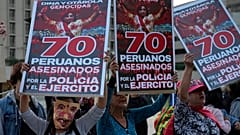 Manifestantes seguram cartazes onde se lê "70 peruanos mortos pela polícia e pelo exército", Lima, Peru