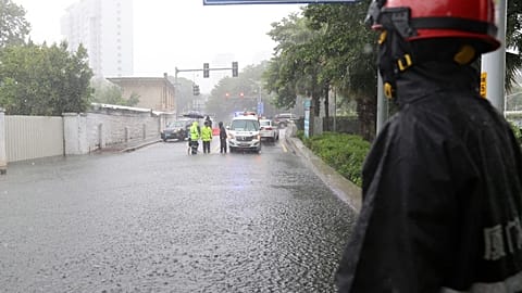 Firefighter surveills a cordonened off area under heavy rainfall during Typhoon Doksuri 