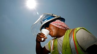 El obrero de la construcción Miguel Gómez descansa del calor mientras trabaja en un centro comercial.
