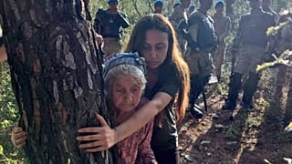 88-year-old Zehra Yıldırım hugging a tree to protect it from being felled on 26 July. She is shielded by activist leader Esra Işık.