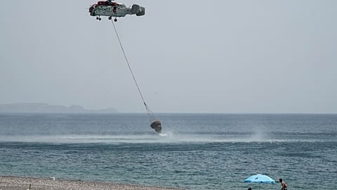 Emergency services take water from the sea in Greece.