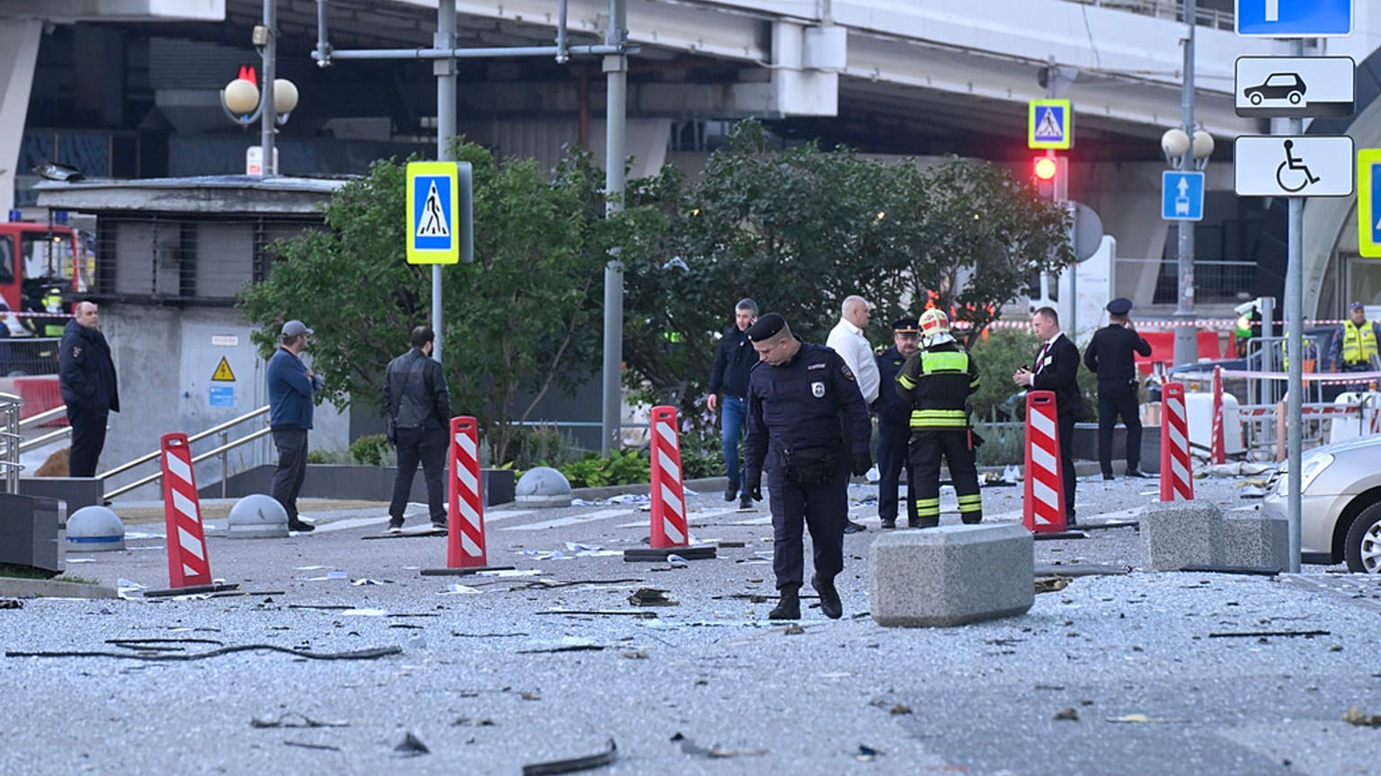 Investigators examine an area next to the damaged skyscraper in the "Moscow City" business district after a reported drone attack in Moscow, Russia, early Sunday, July 30, 202
