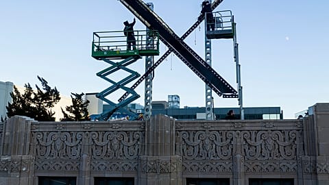 Workers install lighting on an "X" sign atop the San Francisco building that housed what was formally known as Twitter, now rebranded X by owner Elon Musk, July 28, 2023