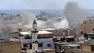 Дым поднимается над районом столкновений в лагере