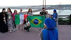 Католические паломники на фоне Моста 25 апреля в Лиссабоне