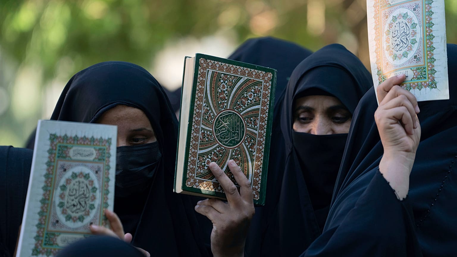 Iraqis raise copies of the Quran, Muslims' holy book, during a protest in Baghdad, Iraq, Saturday, July 22, 2023