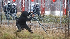 Un hombre derriba la valla durante los enfrentamientos con guardias fronterizos polacos en la frontera entre Bielorrusia y Polonia, cerca de Grodno, Bielorrusia, el martes 16 de noviembre de 2021.